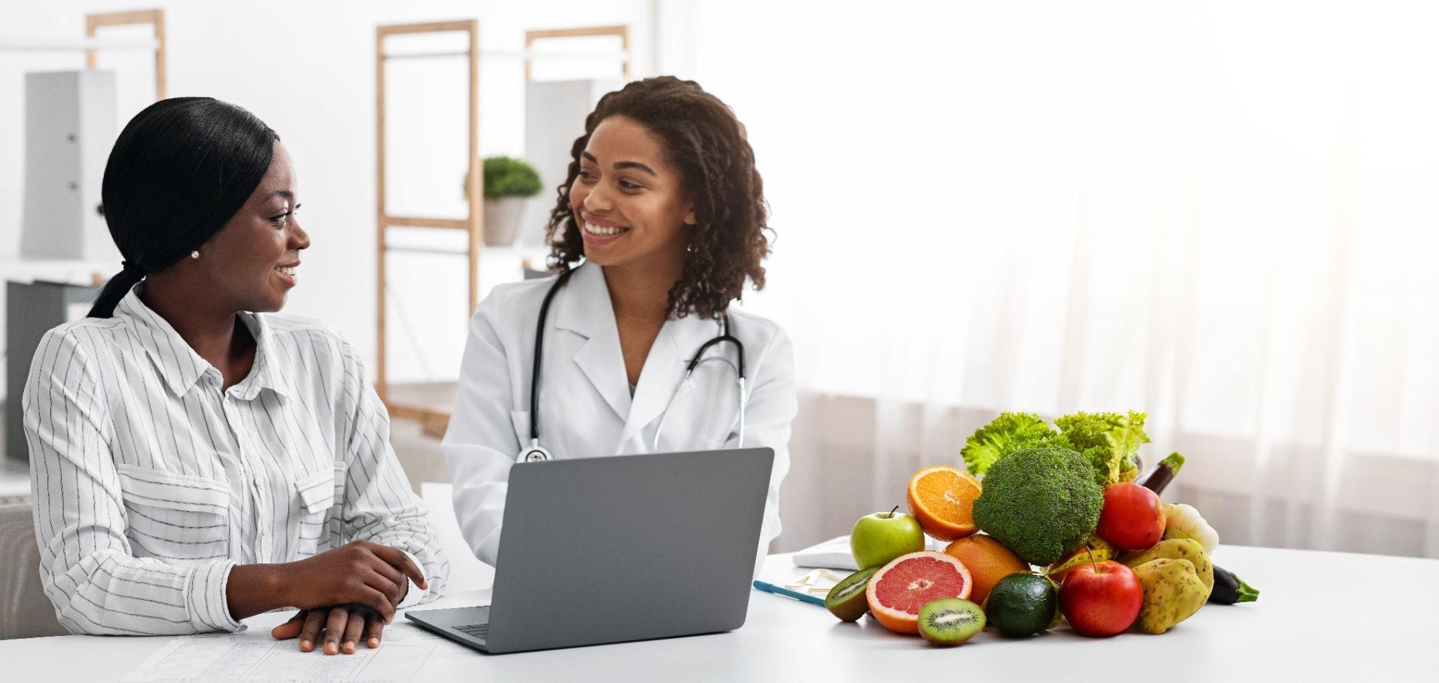 Smiling doctor at East Point Weight Loss clinic Smiling doctor at East Point Weight Loss clinic talking with a patient about nutrition, healthy eating, and personalized weight management plans.